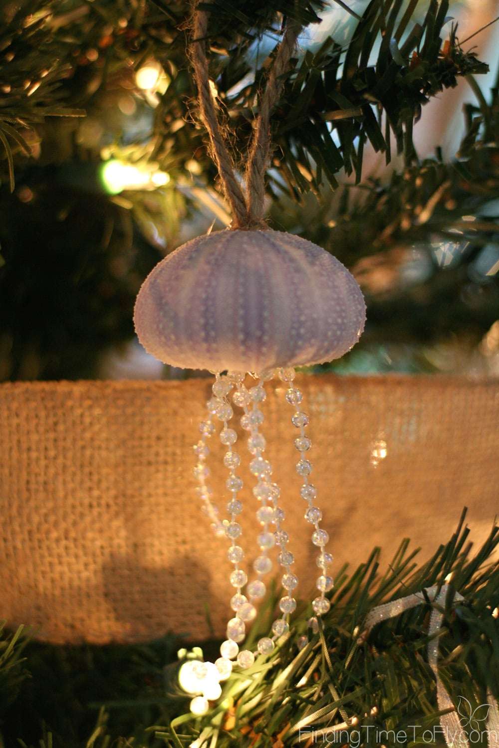 Coastal Christmas Keeping Room with elegant fireplace mantle, seashell Christmas trees, starfish garland and seashell ornaments