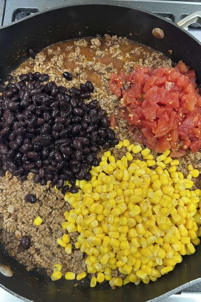 Add tomatoes, corn and beans to skillet