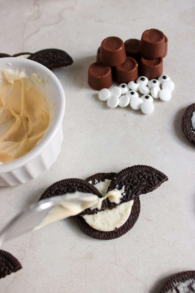Take the Oreo apart and break the top in half