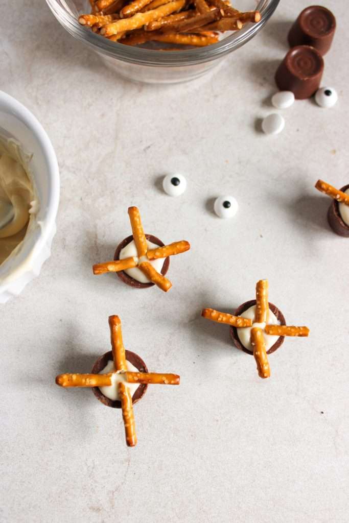 Add pretzel legs to bottom with melted chocolate