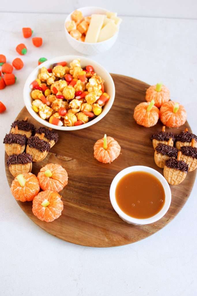 Place the small bowls of popcorn mix and caramel sauce first.