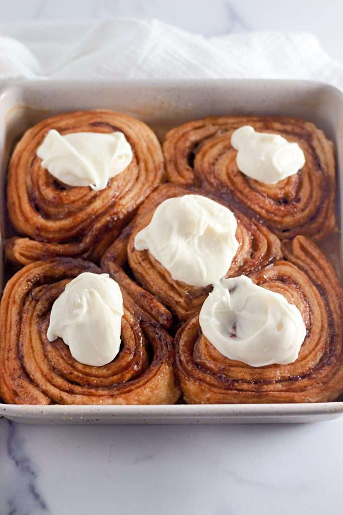 Add frosting to cinnamon rolls while warm