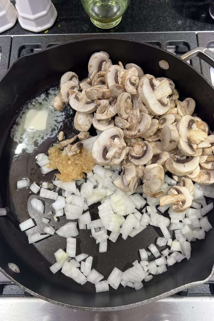 Add onions, garlic, mushrooms, butter, and olive oil to the skillet.