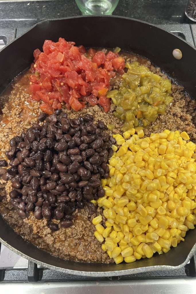 Add black beans, corn, Rotel, and green chilies.