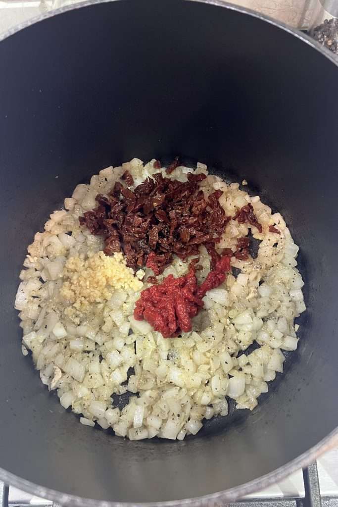 Add garlic, sun-dried tomatoes, and tomato paste.