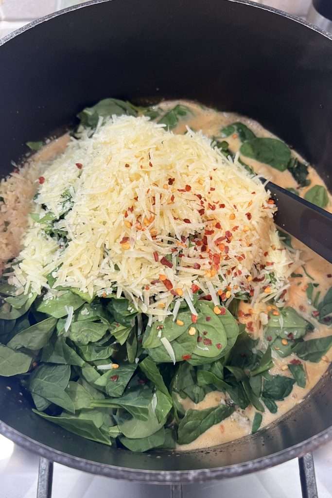 Add chicken, parmesan cheese, and spinach. Cook until spinach has wilted and chicken is heated up.