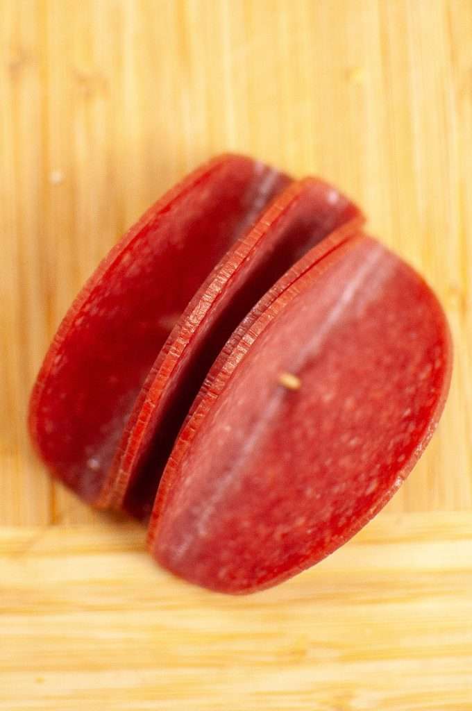 Fold pepperoni slices and stick with a toothpick