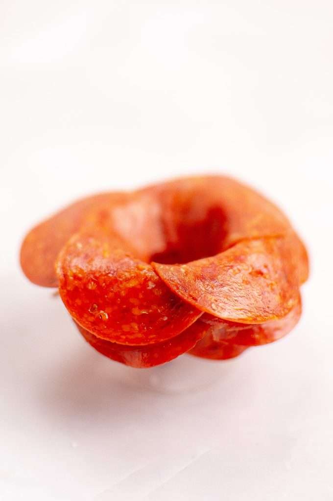 Fold salami pieces around the rim of a small glass to form a rose