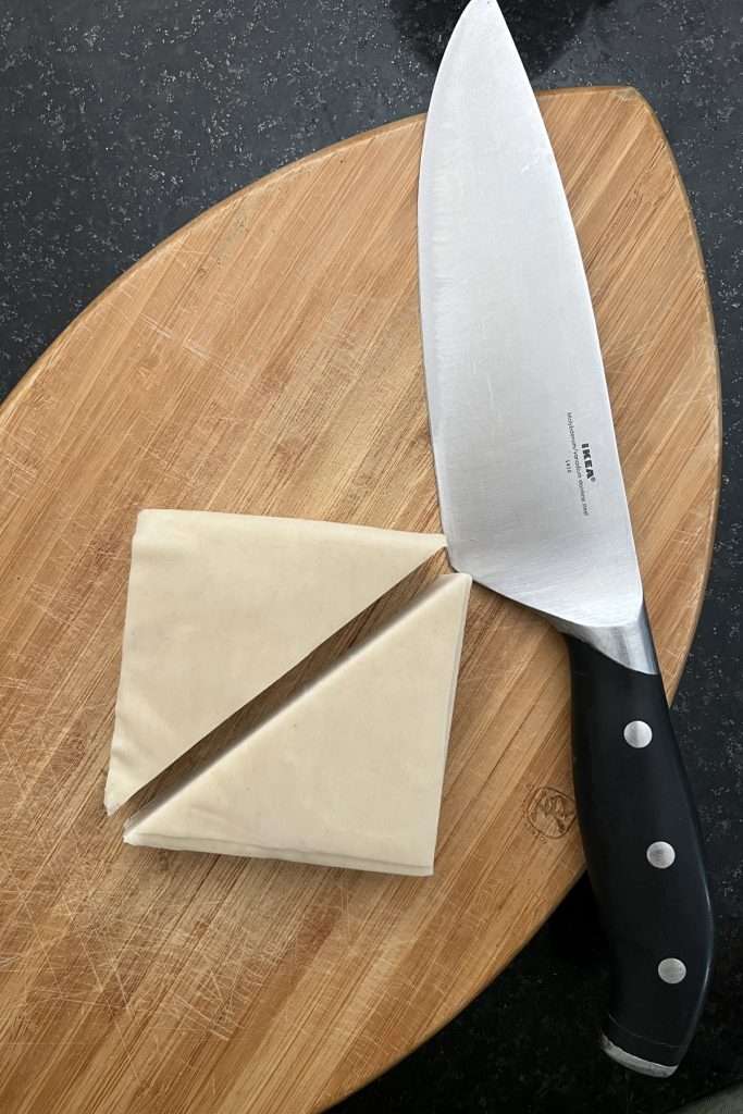 Cut wonton wrappers in half diagonally.