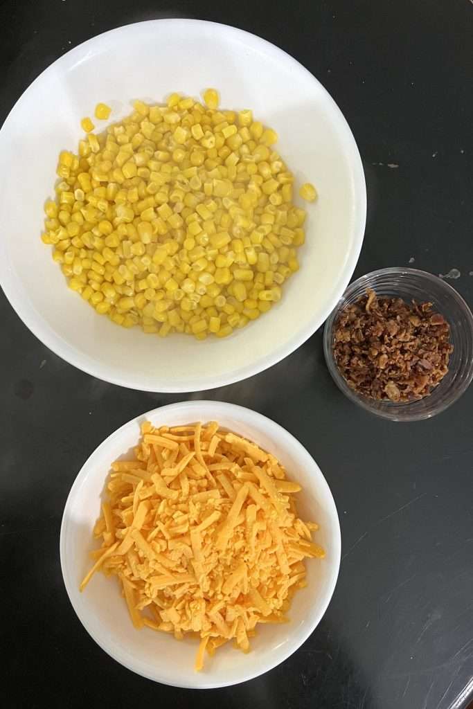 Cook corn, shred some cheddar cheese, and crumble cooked bacon
