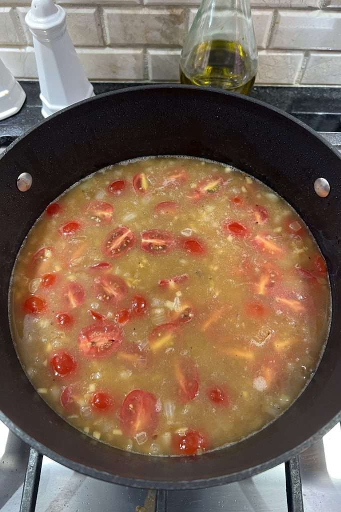 Add lemon juice, chicken broth, and sliced grape tomatoes