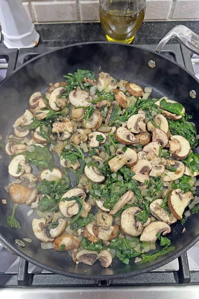 Saute veggies until spinach is wilted and mushrooms are soft.