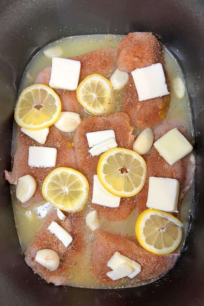 Add garlic cloves, butter, and lemon slices