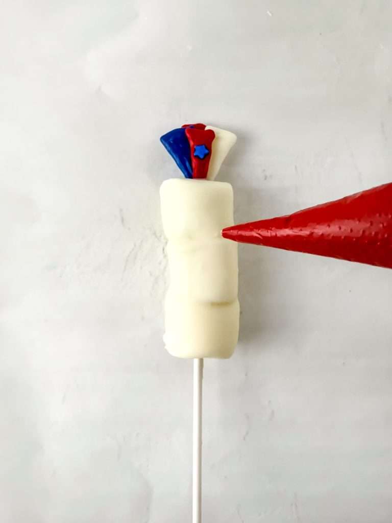 Pipe red and blue chocolate onto the pops.