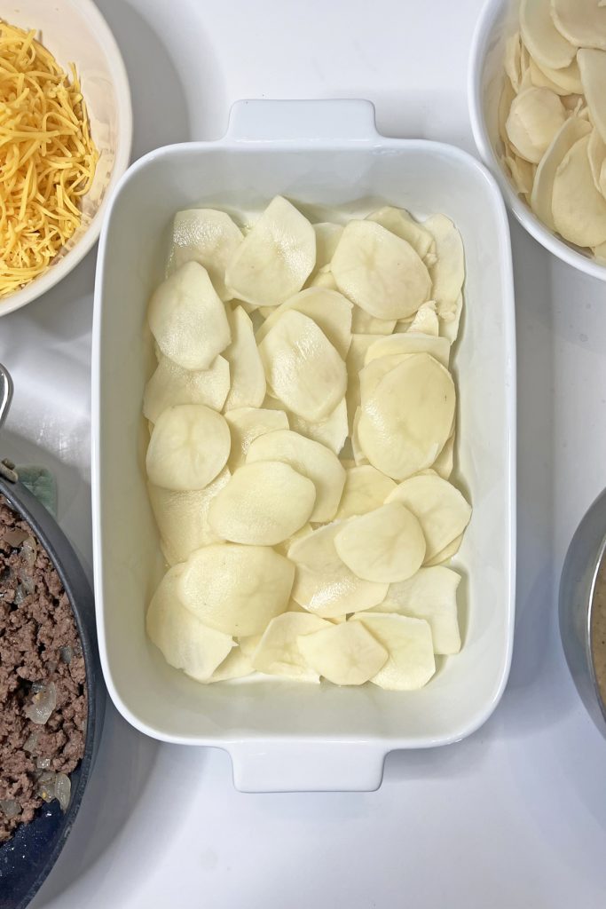Add half of the sliced potatoes