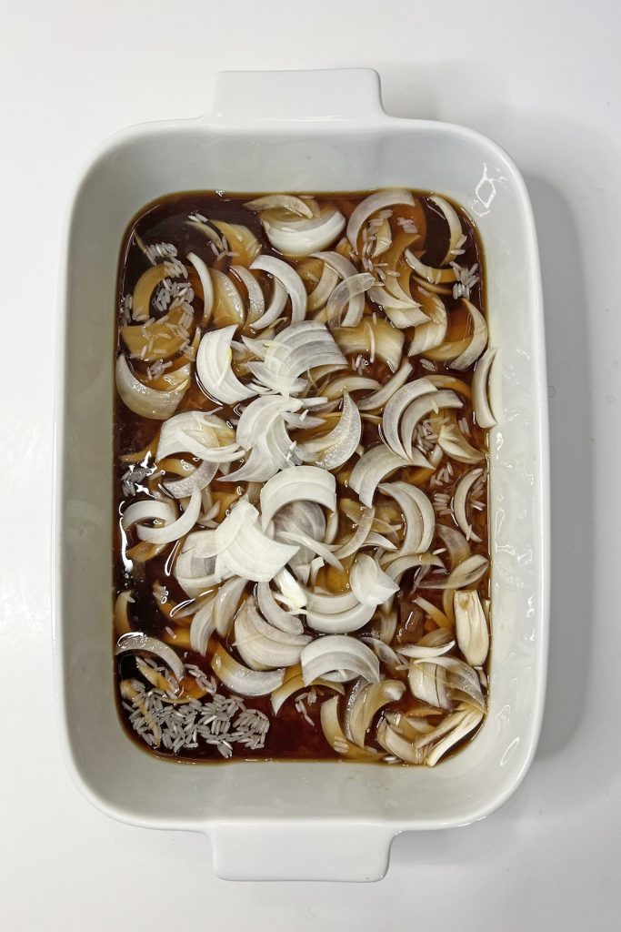 Soup and onions in a casserole dish.