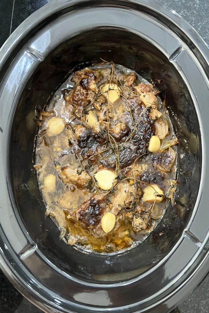 Cooked stew meat in a crockpot.