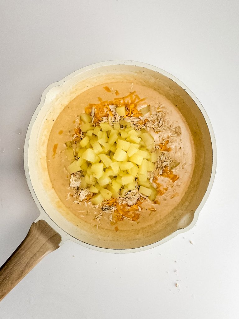 Stir in the shredded chicken, potatoes, and cheese.