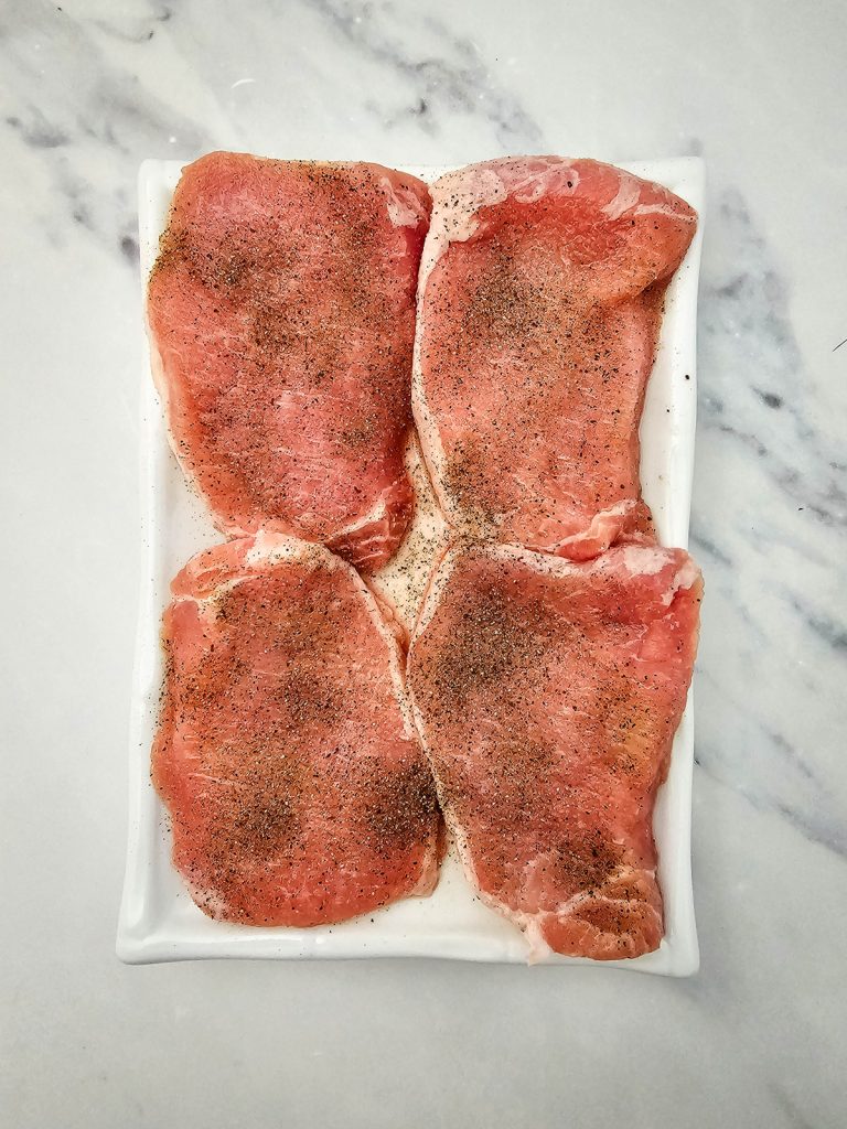 Season both sides of the pork chops.