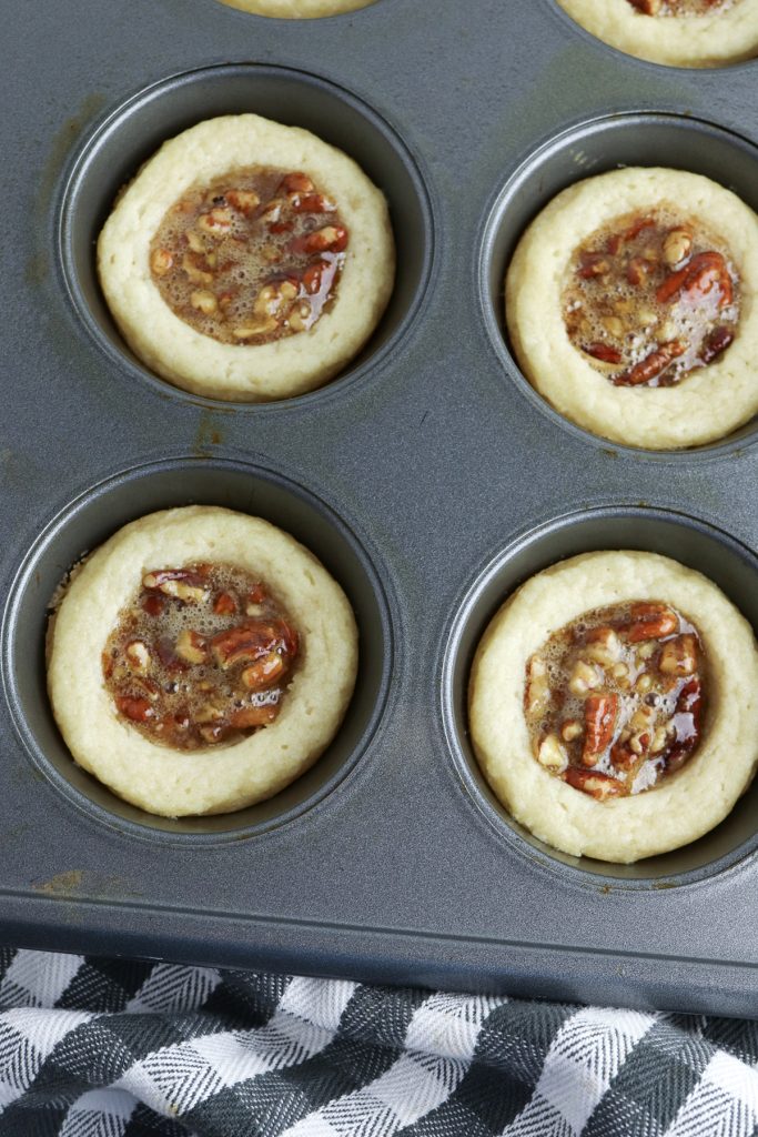 Pecan tarts in a muffin tin ready to bake