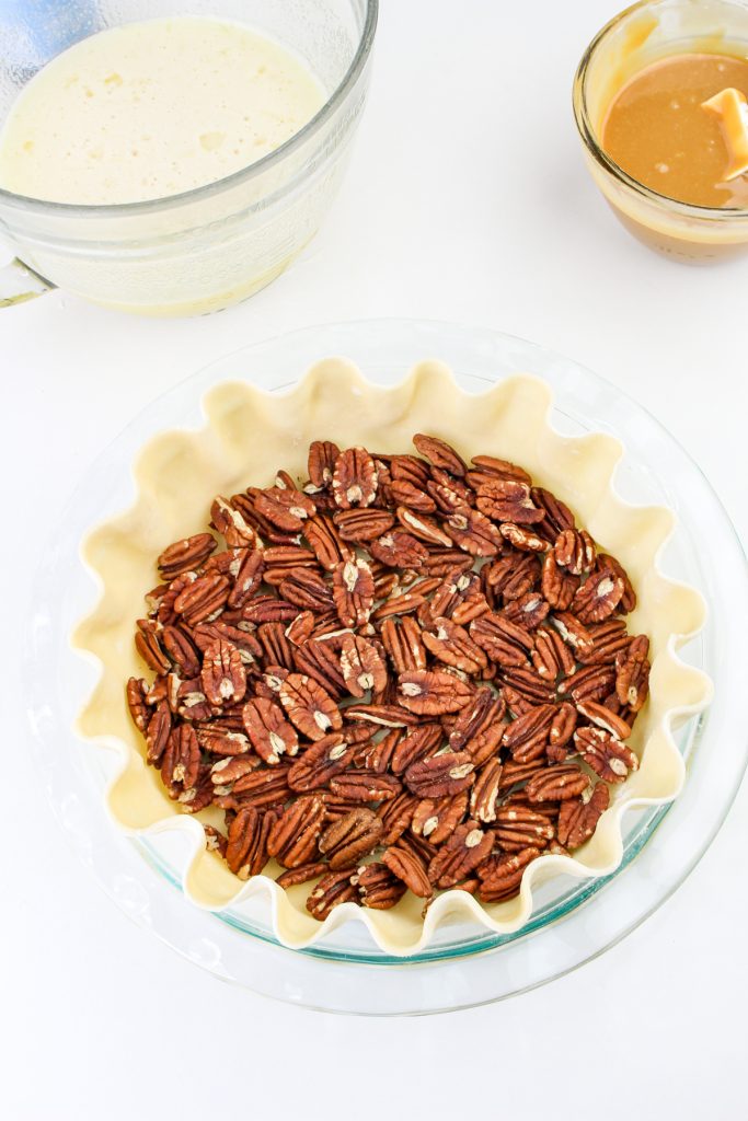 Place a layer of pecan halves on the bottom of the pie crust.
