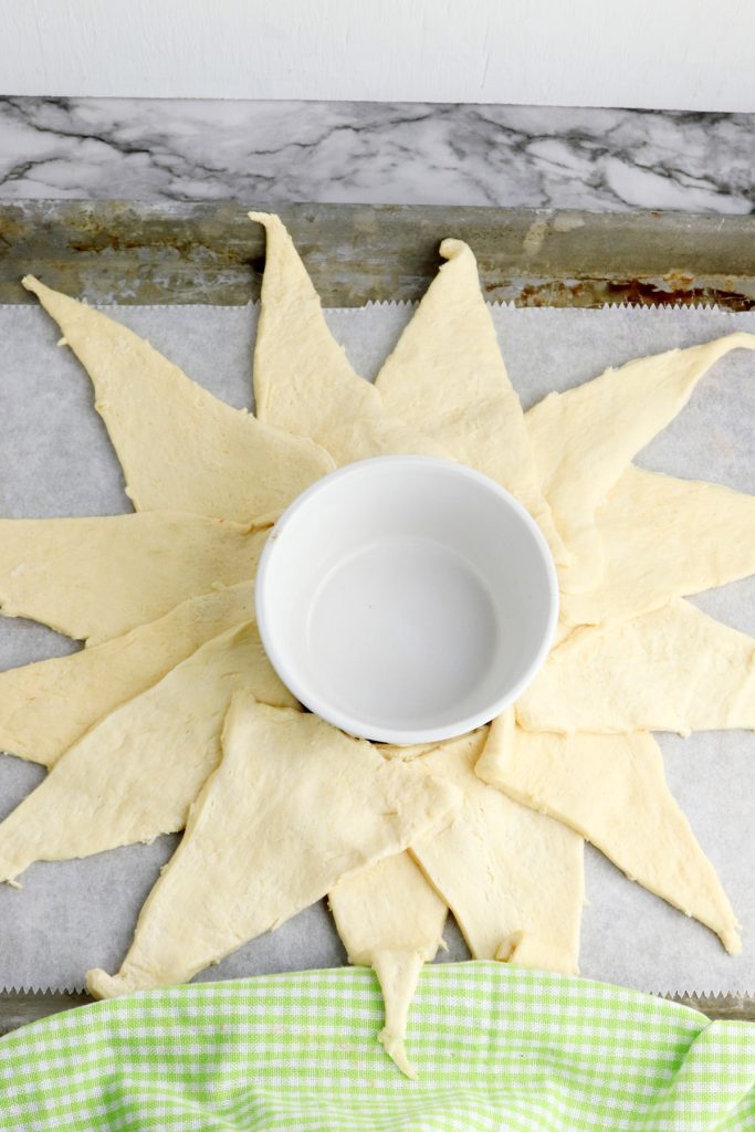 Place a small bowl in the center of your baking dish, then place crescent rolls around it.