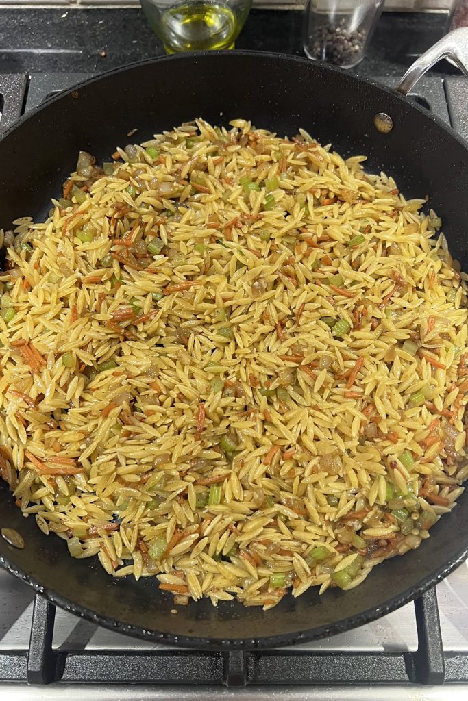 Saute the orzo to coat and toast.