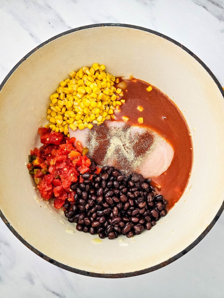 Chicken, corn, Rotel, black beana, and enchilada sauce in a Dutch oven.