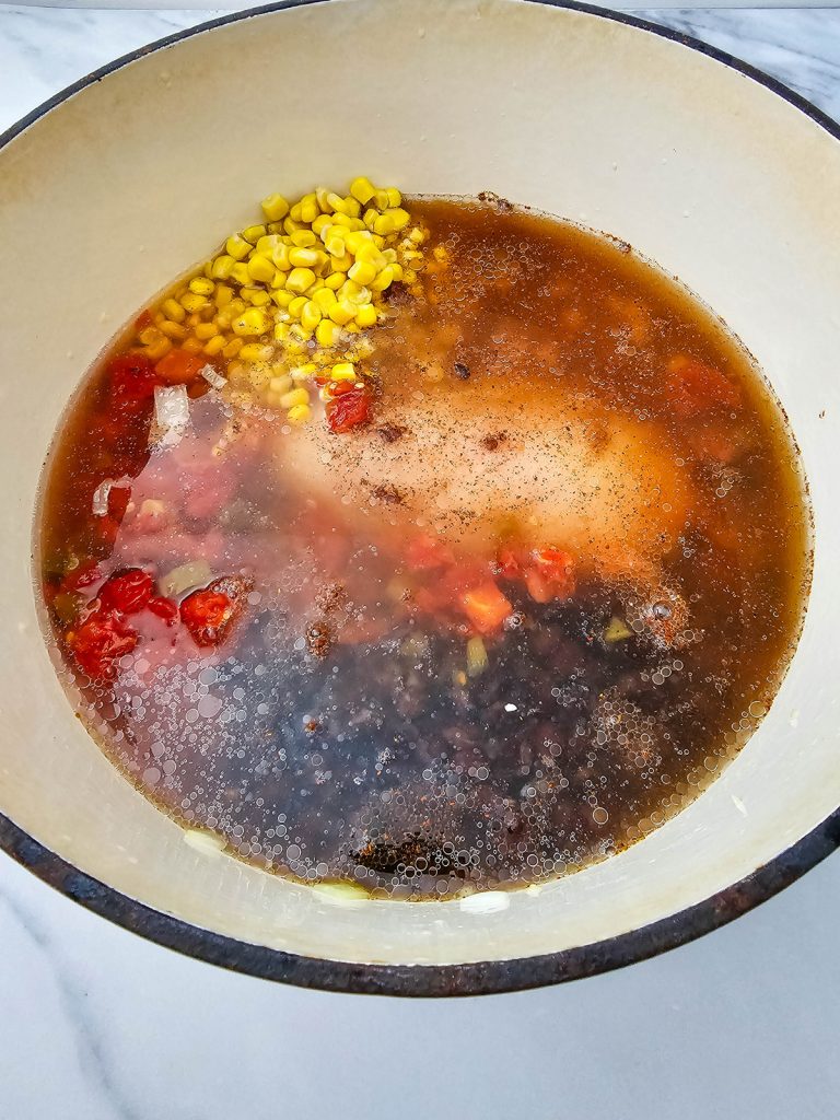 Chicken enchilada soup ingredients in a Dutch oven.