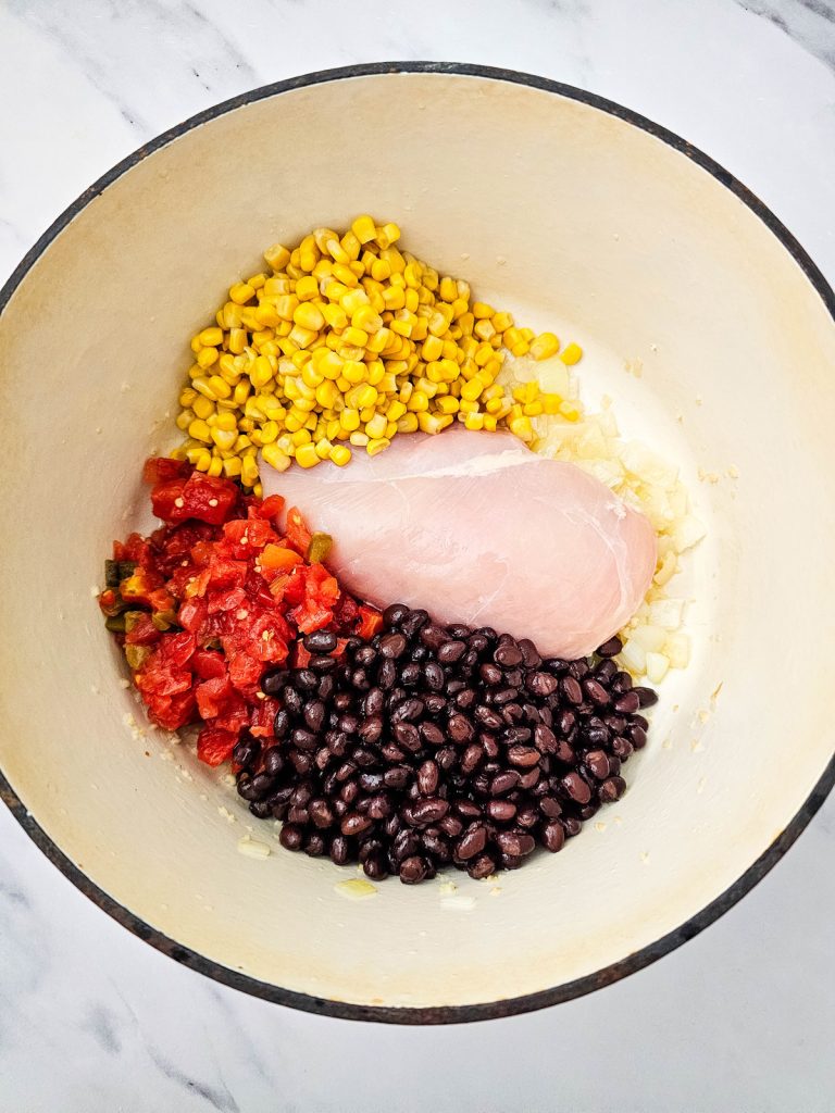Chicken, corn, black beans, and Rotel in a Dutch oven.