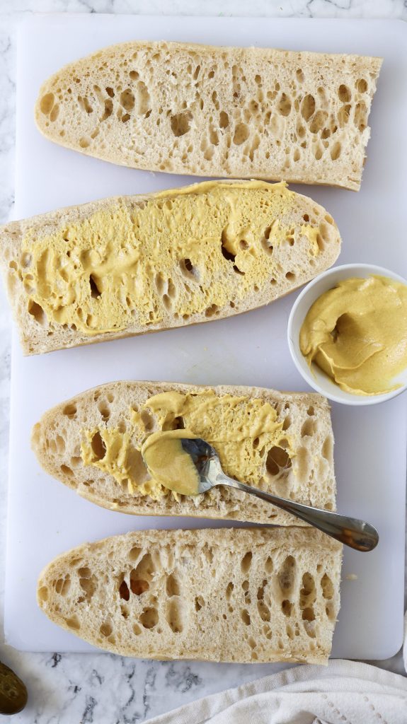Sliced bread with mustard spread on it.