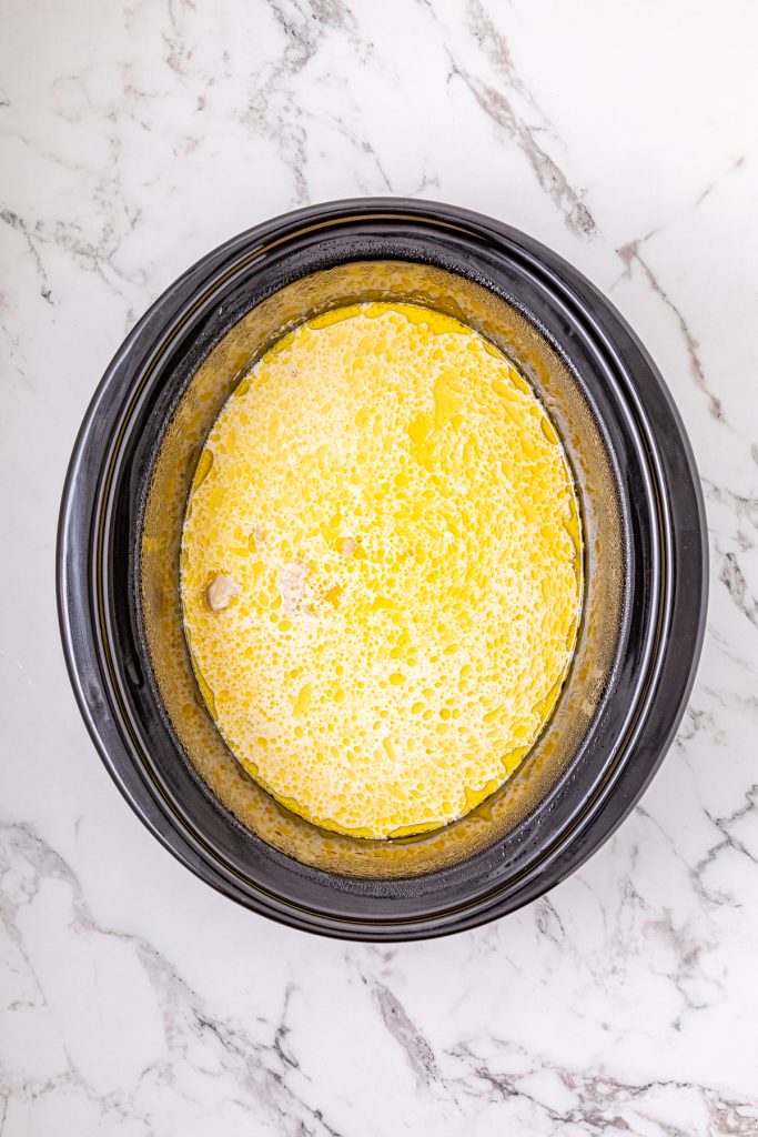Alfredo sauce cooking in a crockpot.