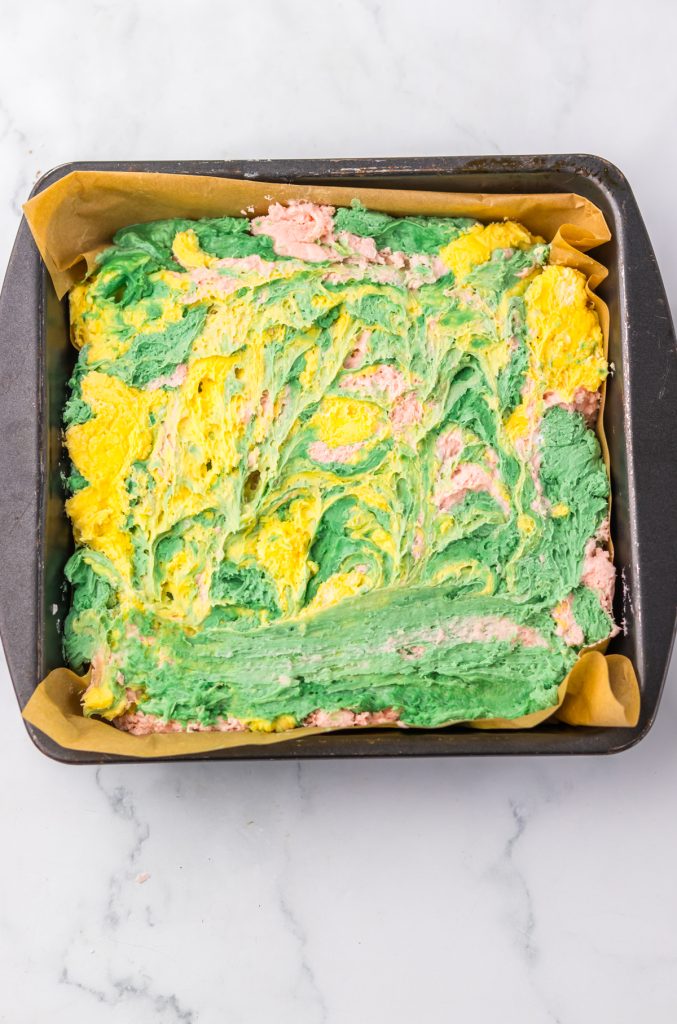Cool Whip and candy melts of different colors swirled in a pan.