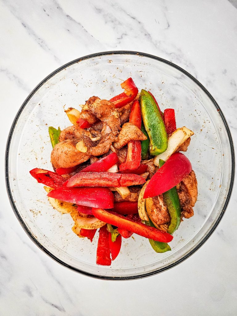 Chicken and veggies seasoned in a bowl.
