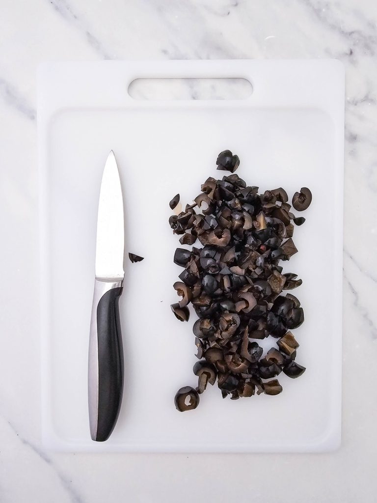 Sliced black olives on a cutting board.
