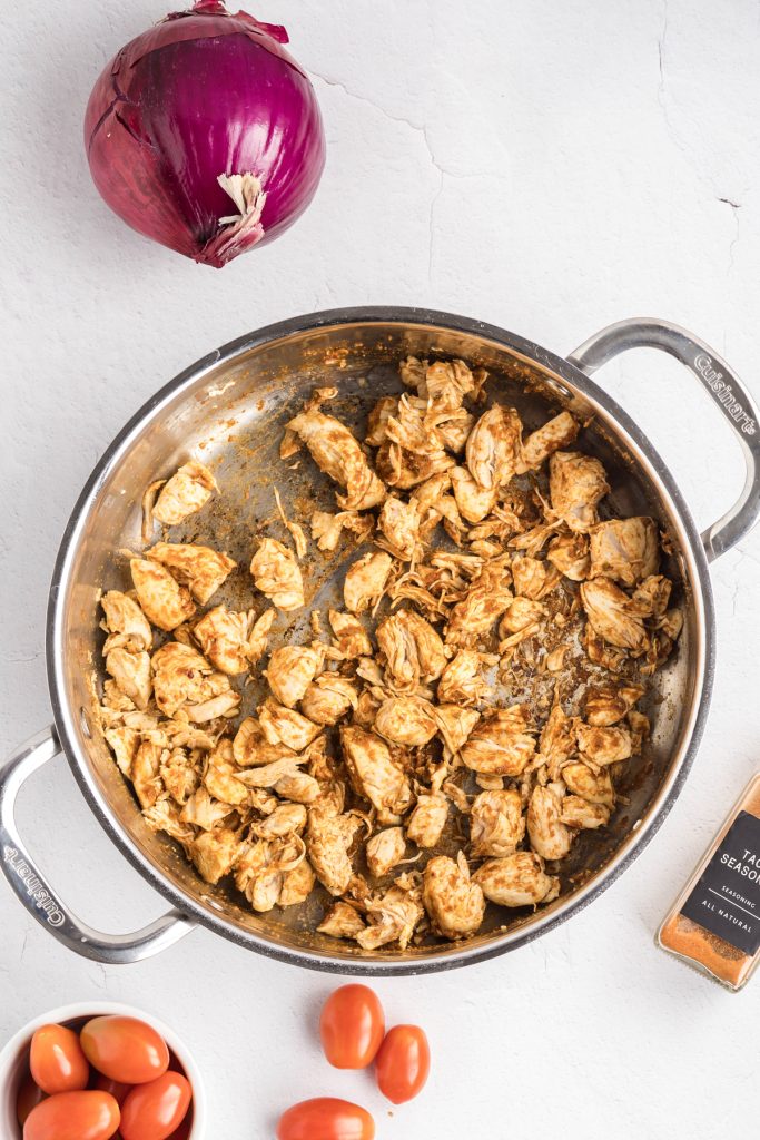 Seasoned chicken in a skillet.