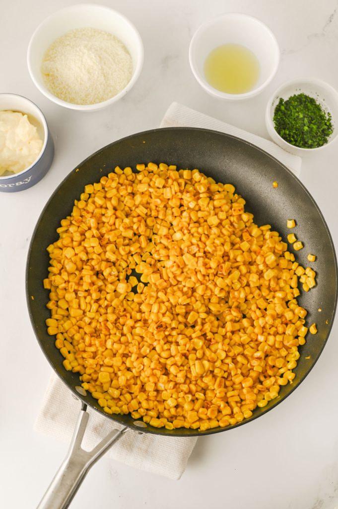 Charring corn in a skillet.