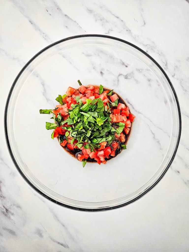 Bruschetta ingredients in a glass bowl.