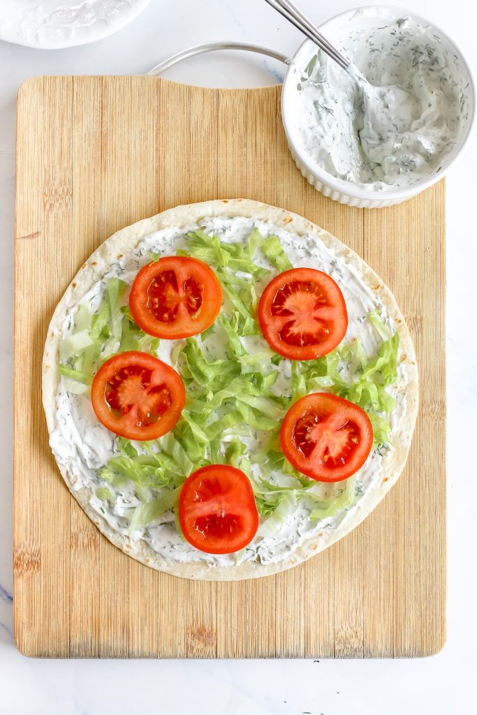 Add a layer of shredded lettuce and thinly sliced tomatoes.