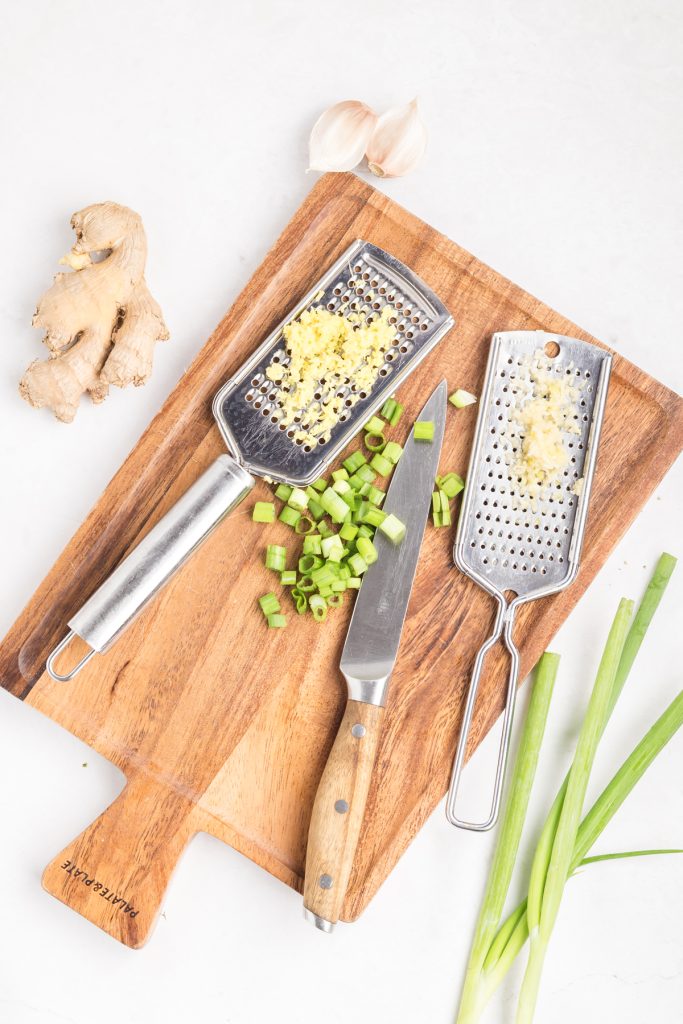 Grate the ginger and chop the green onions.