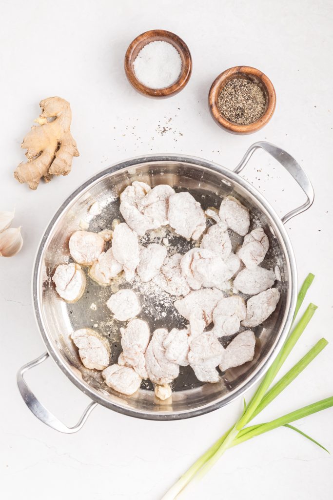 Cook coated chicken pieces in a skillet.